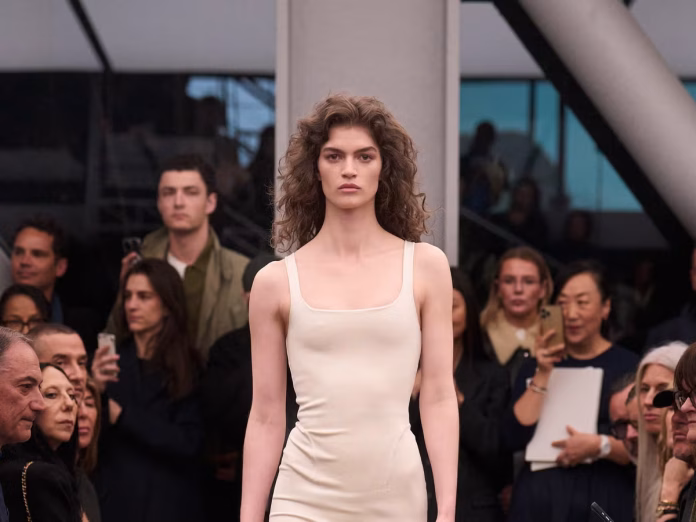 4acde84d-ccb6-4c7c-b7ba-fab83652e008 Pieter Mulier Alaïa 2026, Alaïa final collection, swan song Versace move, Azzedine Alaïa legacy, precision silhouettes Alaïa, restrained elegance fashion, Summer-Fall 2026 review, WWD runway review, form-hugging velvet suits, ruffled skirts Alaïa, real luxury definition, team portraits tribute, techno soundtrack fashion, iteration in design, connoisseur appeal, Mulier Versace transition, body architecture Alaïa, emotional storytelling couture, pitch-perfect finale, house codes evolution
