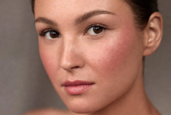 Model wearing boyfriend blush trend makeup with naturally flushed cheeks and soft skin-focused beauty styling