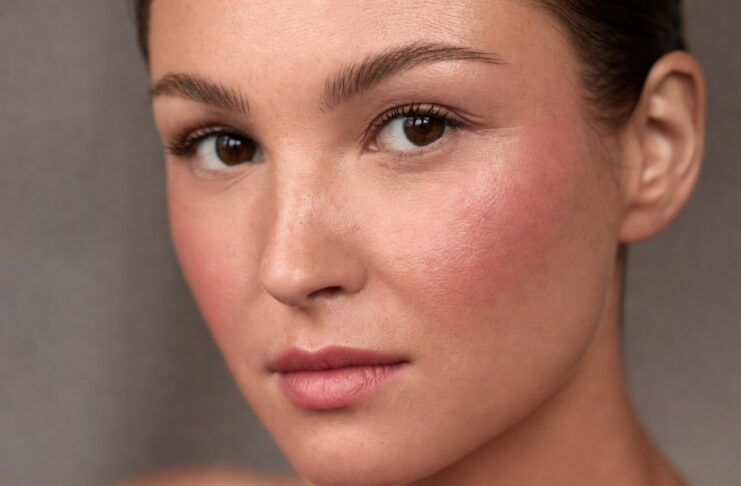 Model wearing boyfriend blush trend makeup with naturally flushed cheeks and soft skin-focused beauty styling