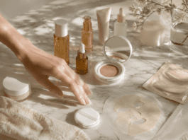 Curated collection of K-beauty skincare products including PDRN serums, cushion foundations, and toner pads arranged on marble for a glass skin routine guide