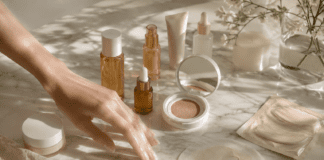 Curated collection of K-beauty skincare products including PDRN serums, cushion foundations, and toner pads arranged on marble for a glass skin routine guide