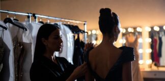 The Stylists Behind the Biggest Red Carpet Moments A red carpet stylist making final adjustments to a custom gown backstage representing Runway Magazine's complete guide to the stylists behind the biggest red carpet fashion moments