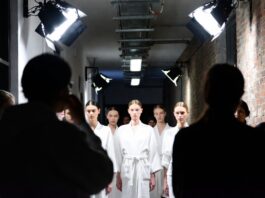 Fashion week models lined up backstage before a runway show, illustrating who gets booked for fashion week and why