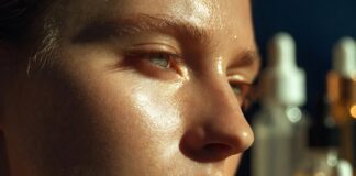 Model with luminous glass skin finish under fashion week backstage lighting, representing Runway Magazine's complete guide to glass skin skincare preparation for runway models