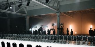 NYFW Schedule: How Shows Are Booked & Sequenced Empty New York Fashion Week runway with production crew preparing the venue before the show, illustrating how the NYFW schedule is built and sequenced