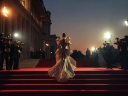 A figure in a sculptural designer gown arrives on the red carpet at a major award show ceremony, representing Runway Magazine's complete red carpet fashion hub