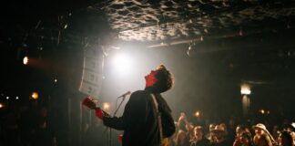 Why Major Artists Are Suddenly Choosing Tiny Venues Over Stadium Tours Artist performing during an intimate small venue concert in 2026