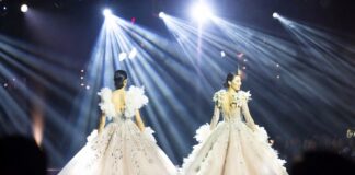 Model mid-stride in a dramatic feathered ball skirt on a Paris Fashion Week runway representing the breakout models 2026 season and the emergence of Awar Odhiang, Achol Ayor, and Stella Hanan as the next generation of luxury fashion stars