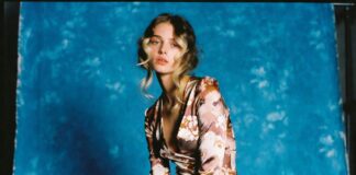 Jacqui Hooper’s Rise From Festival Discovery to Luxury Fashion Favorite Young British model in floral luxury dress against vibrant blue backdrop representing Jacqui Hooper model's rise from Reading Festival scouting to Vogue Korea cover and luxury fashion campaign bookings in 2026