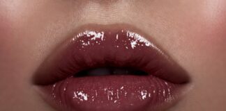 Close-up of lacquered high-shine berry lips in luxury beauty editorial lighting representing the lacquered lips trend 2026 and the shift from matte lipstick to gloss-balm hybrid formulas in celebrity makeup and high fashion beauty