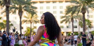 Confident figure in swirl-print one-piece swimsuit mid-stride on a Miami runway representing Megan Thee Stallion swimwear Hot Girl Summer Swimwear PARAISO Miami Swim Week 2026 runway show and viral fashion moment