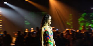 Luli Fama’s Tropical Glamour Proves Miami’s Signature Swimwear Aesthetic Is Still Winning Model in vibrant tropical-print swimsuit on the PARAISO Collins Tent runway representing Luli Fama's SS27 collection at Miami Swim Week 2026 and the brand's 20th anniversary celebration of bold Latin-inspired luxury swimwear by Lourdes Luli Hanimian